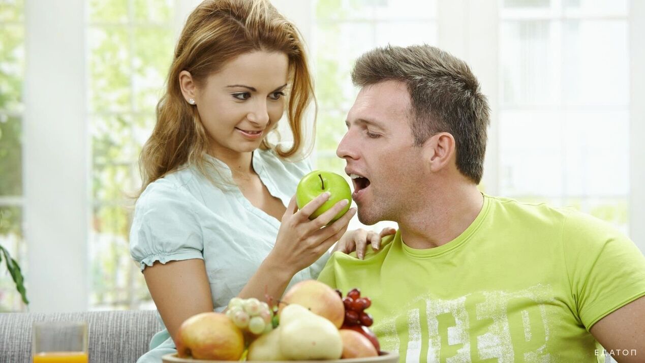 la niña alimenta al hombre con comida saludable